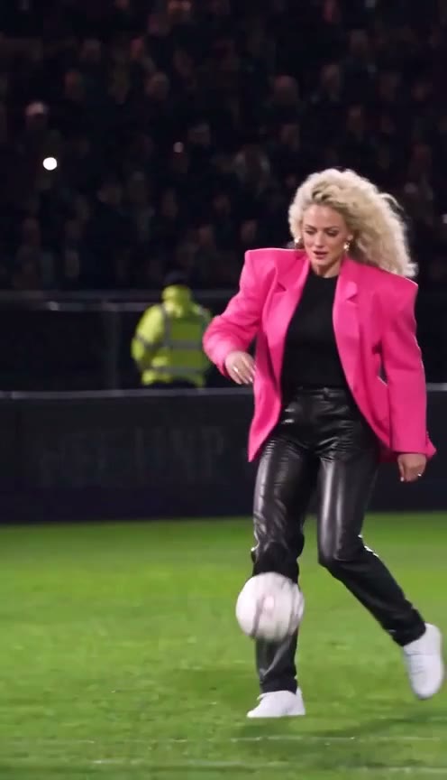 Beat 1 of an Ozil goal AI video: the goalkeeper dives past a woman in a pink blazer on the ball
